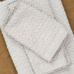 Lattice Cotton/Linen Washcloth in Ice Grey stacked with hand towel and bath sheet