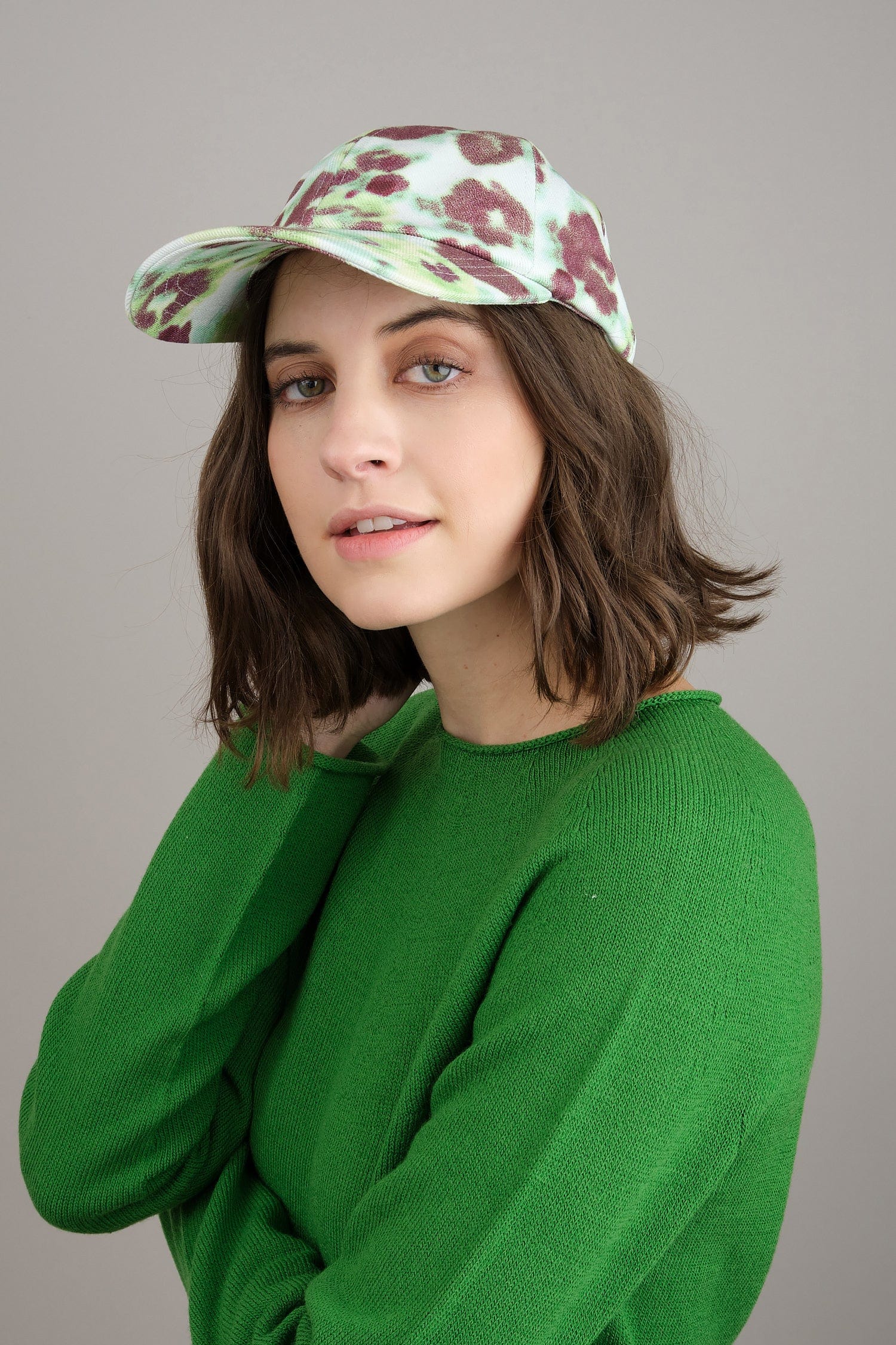 Arat printed cap styled with green Kaliq sweater
