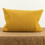 16" X 24" Sheep Vice Versa Cushion in Ocre on table