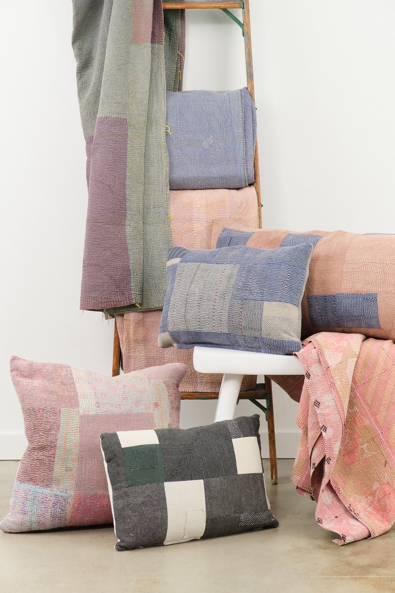 Aloka Home Patchwork cushions and blankets on a chair against a white wall
