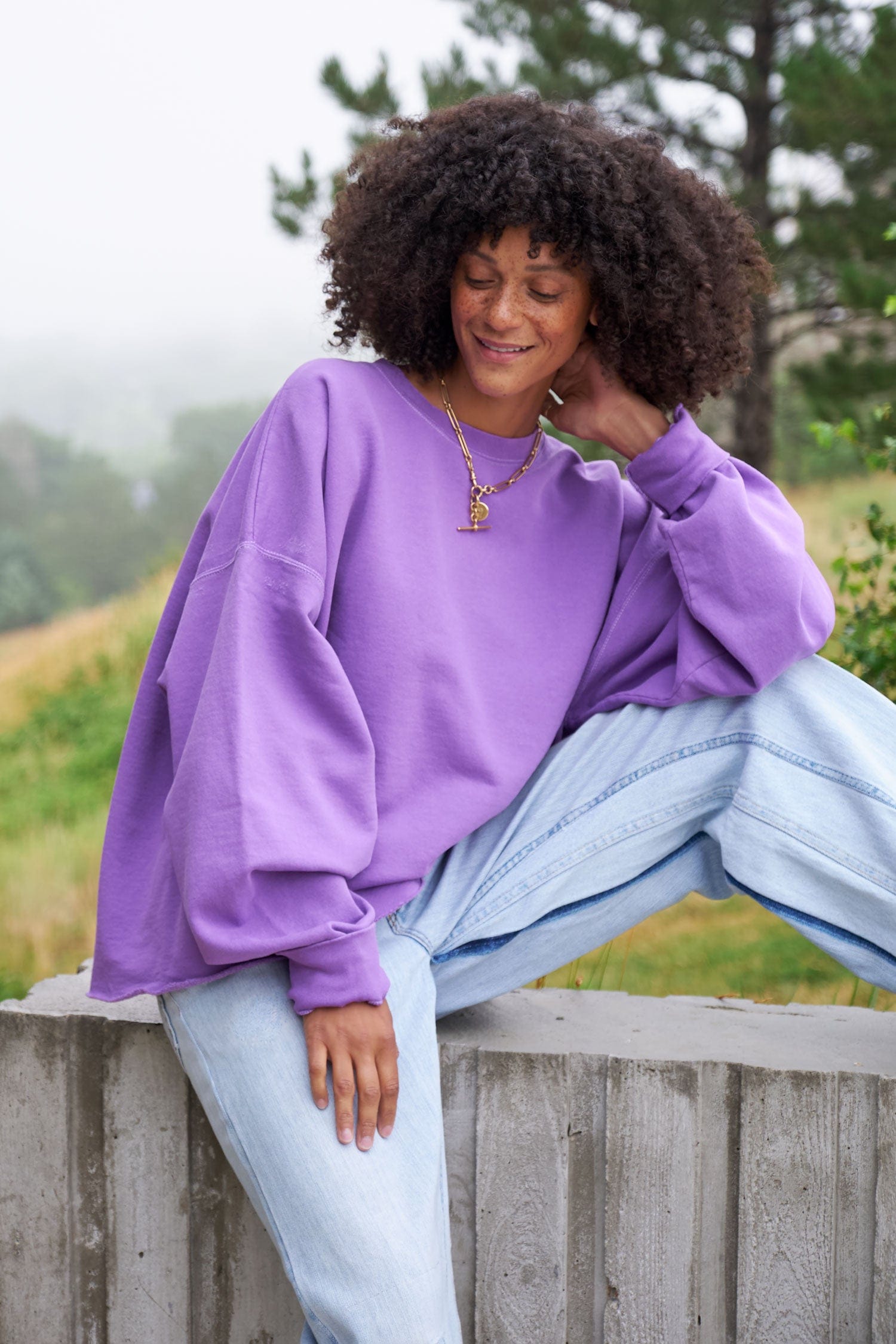 Woman wearing a fonder sweatshirt from Rachel Comey and light blue jeans from B Sides Jeans.