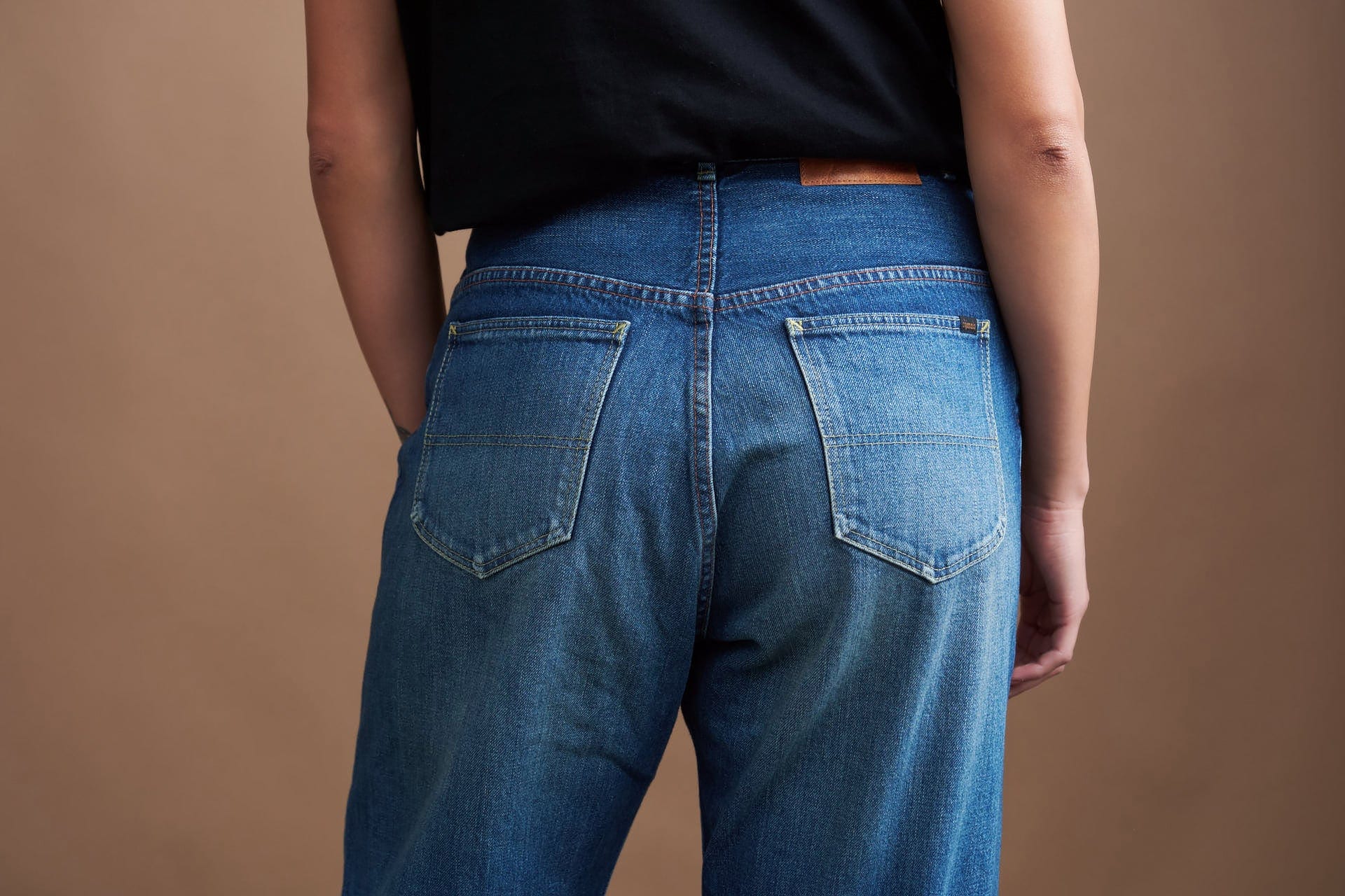 Person wearing chimala japanese blue jeans with a plain brown background