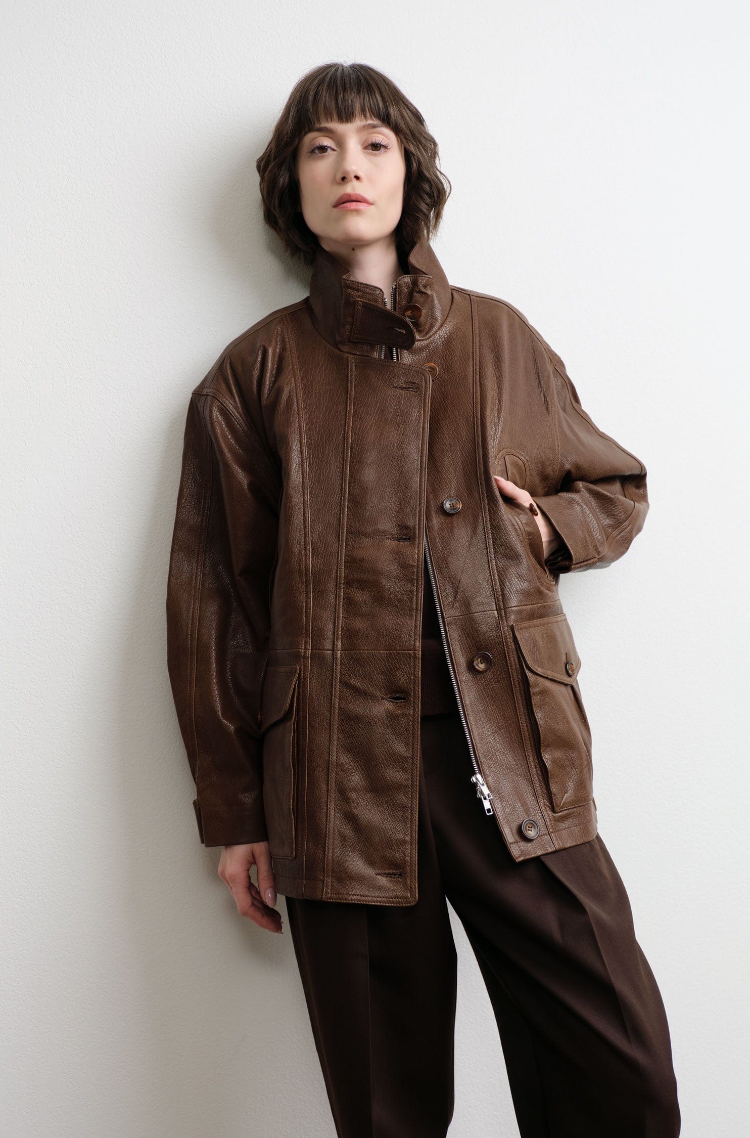 Person wearing a jamie haller brown leather jacket against a white background