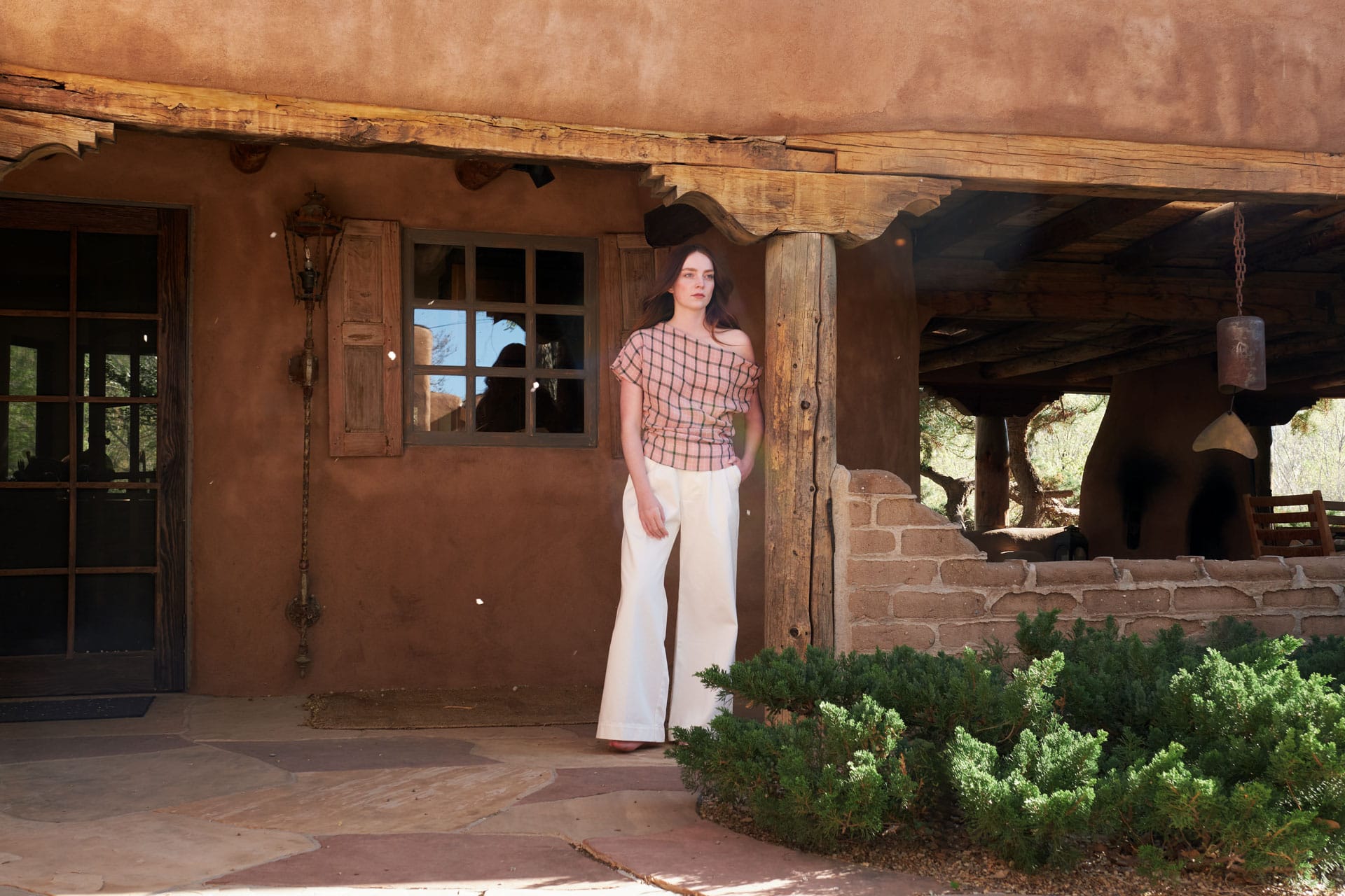 A woman wearing Rachel Comey and Jesse Kamm standing in front of a casita in Taos.