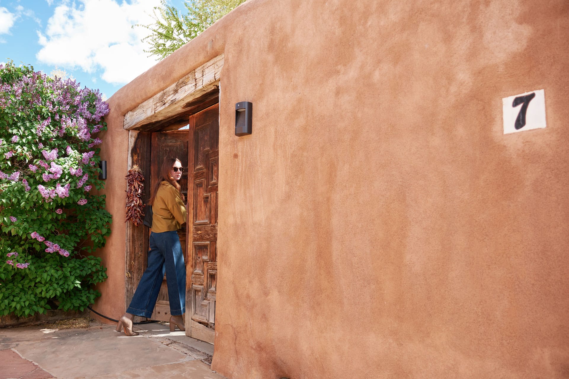 Person standing outside a casita in Taos wearing Black Crane and Jesse Kamm pants.