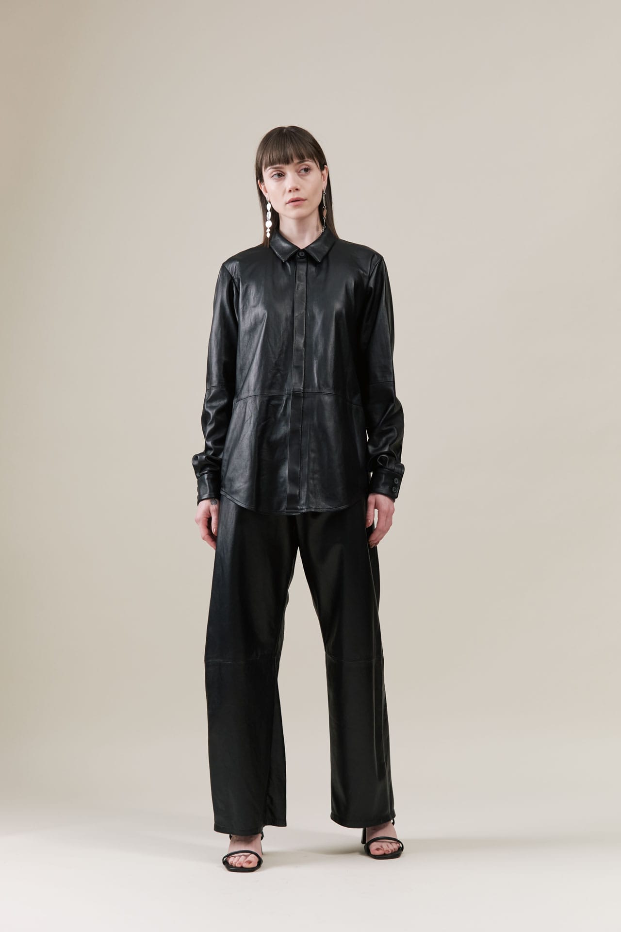 Person wearing a black leather outfit from Lauren Manoogian on a plain background