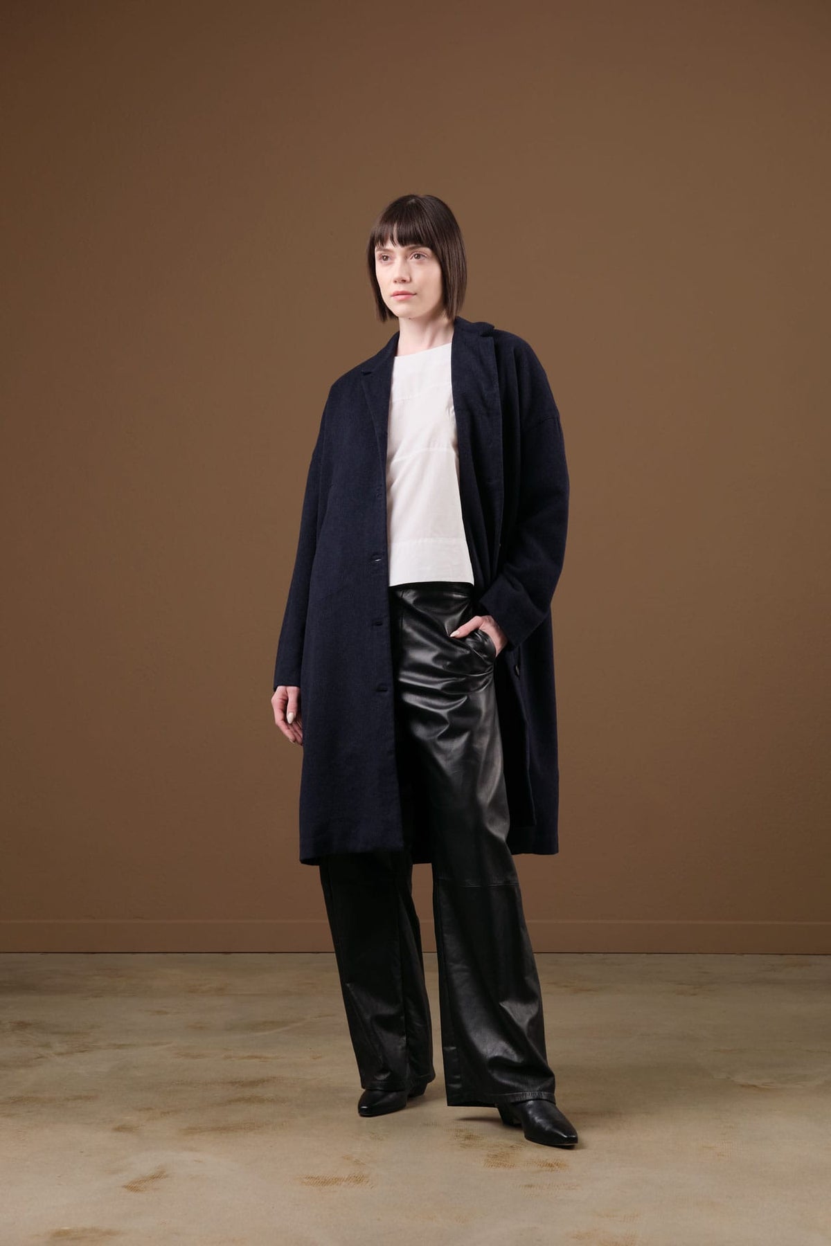 woman wearing lauren manoogian leather pants, rachel comey rugby top, and private 0204 cashmere coat.