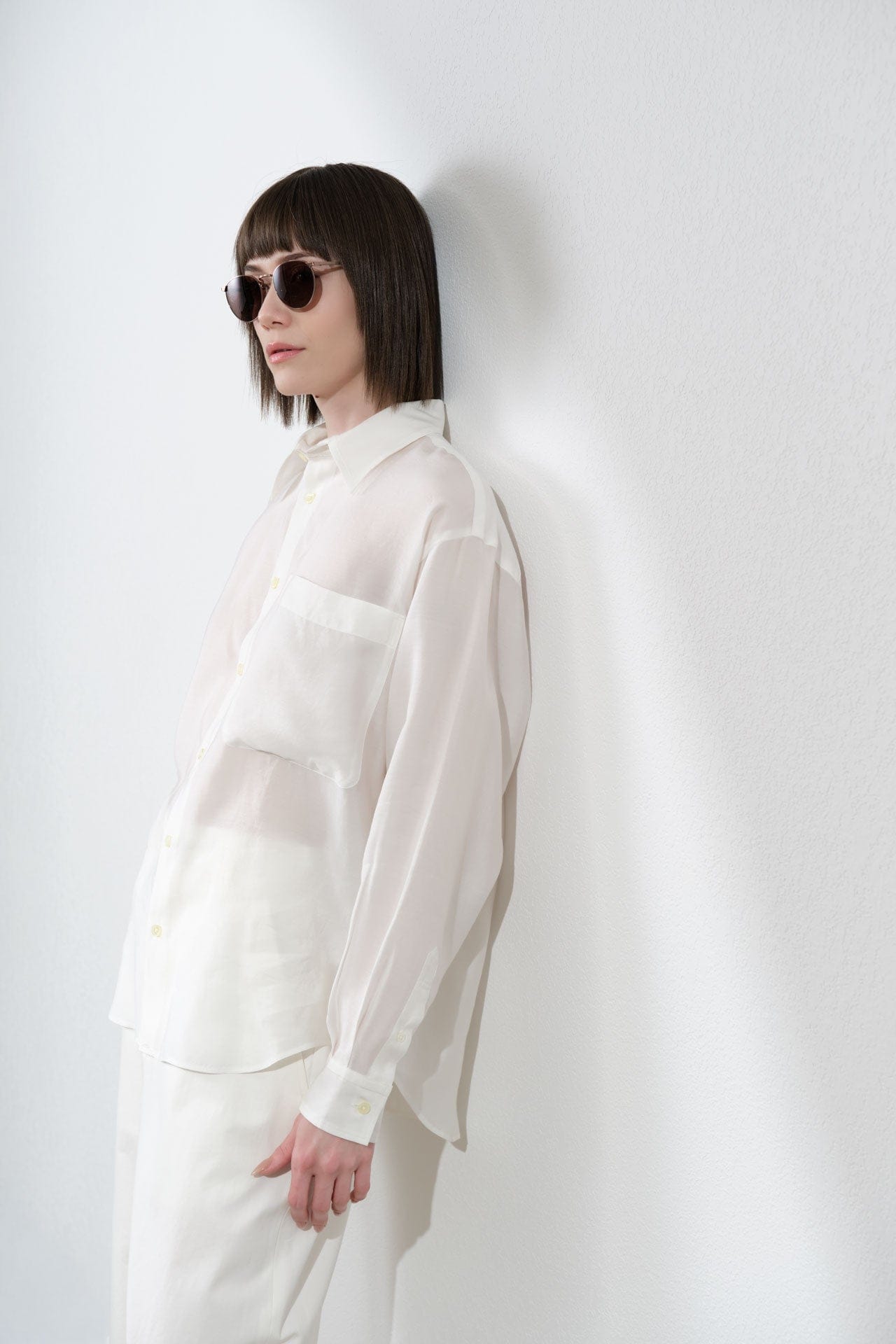 Person wearing a Nicholson & Nichsolon white shirt against a plain background