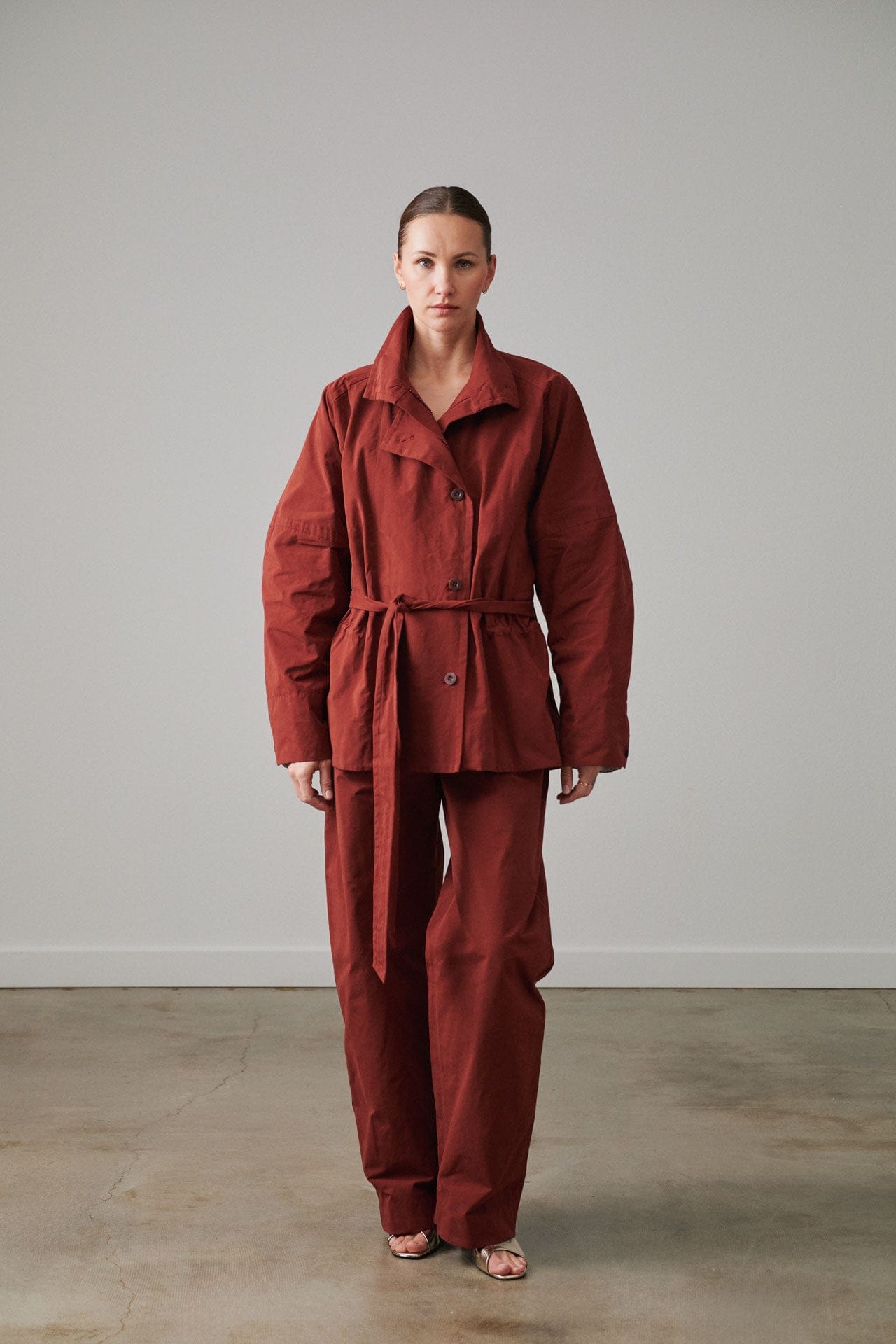 Person wearing a Rachel Comey red modern workwear suit standing against a plain background