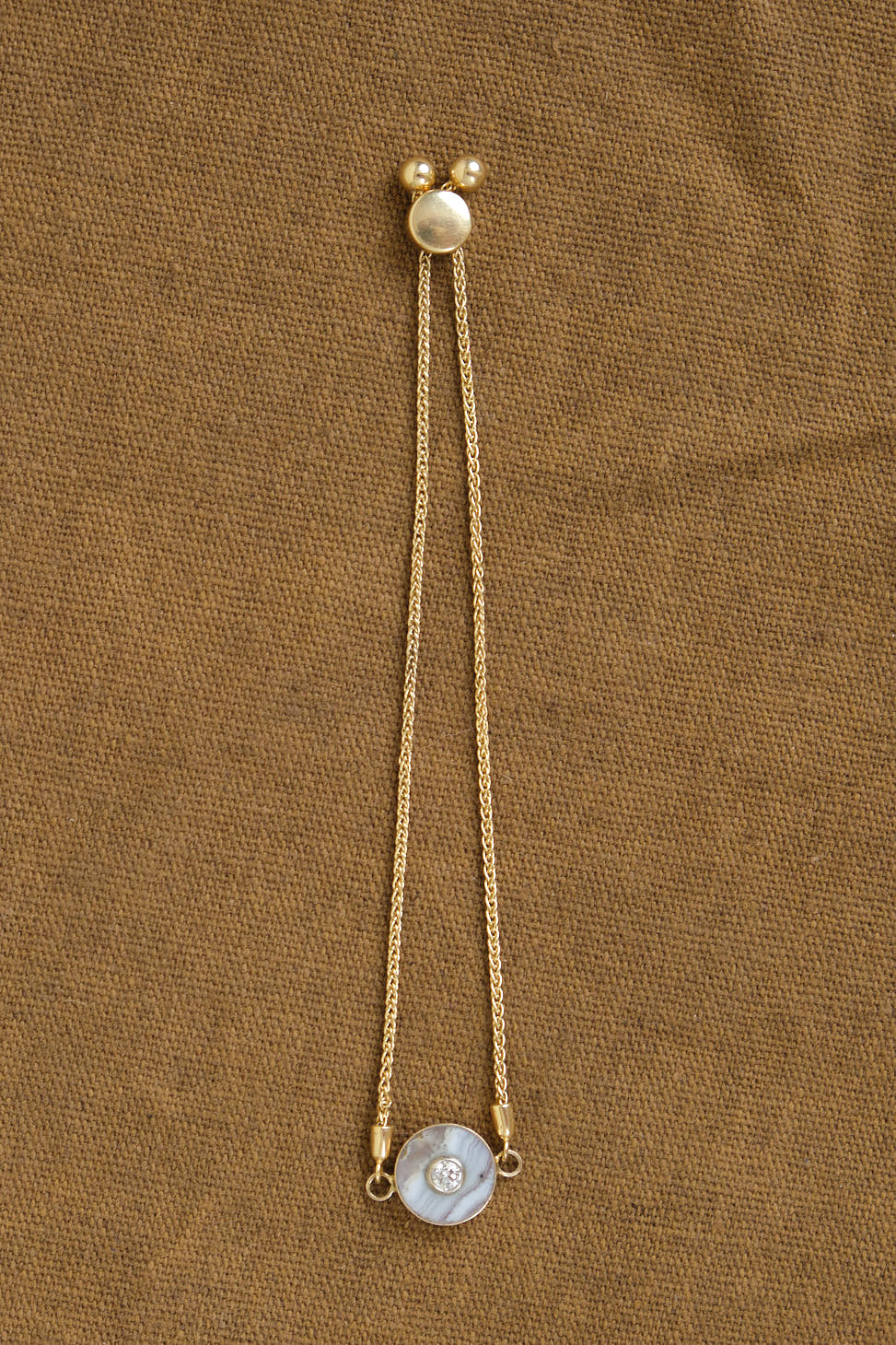 Cerclen Bolo Style Bracelet in Sow Belly Agate on table
