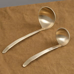 Large and small brass ladles